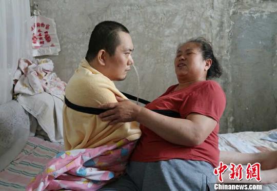 身體日漸衰老的梁青蘭每次幫兒子翻身、坐立，全身的衣物都要濕透一次?！∩忻鱾b 攝