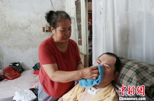 每次喂完食物后，梁青蘭都要仔細(xì)地幫兒子清理干凈?！∩忻鱾b 攝