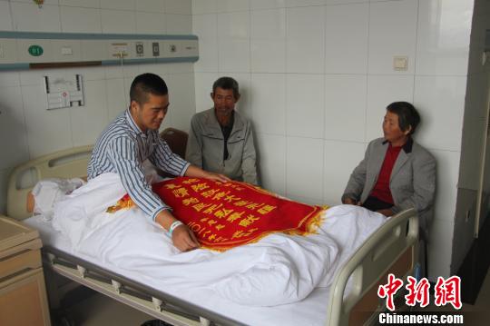 被救的李忠起、張總鳳夫婦看望受傷后的李運(yùn)飛?！⊥粲?攝