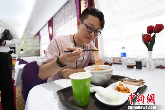 圖為旅客在列車上享用正宗牛肉面?！钇G敏 攝